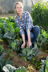 Portrait of smiling young woman working in garden at spring farm