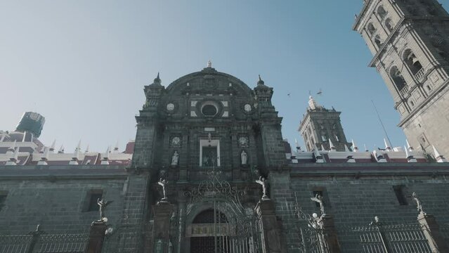 Dolly pov showing entrance of historic Nuestra Senora Cathedral during sunny day in Puebla,Mexico