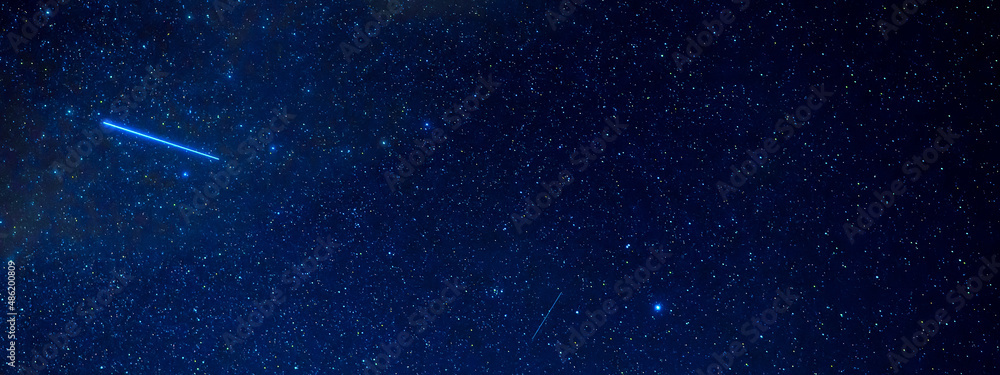 Wall mural panorama of the starry sky at night with a shooting star against the background of many galaxies and