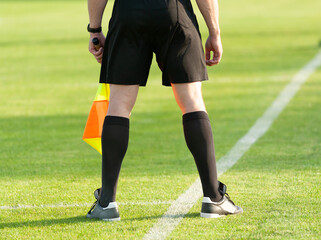 Fototapeta na wymiar Sport. Football. Assistant football referee with a flag on the side edge of the football field