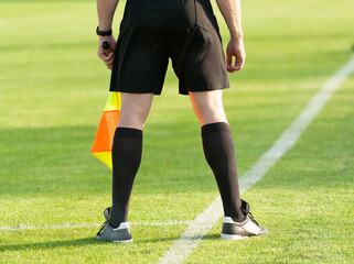 Sport. Football. Assistant football referee with a flag on the side edge of the football field