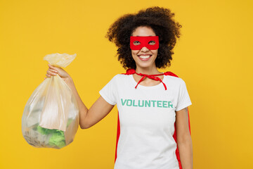Young woman of African American ethnicity in white volunteer t-shirt super hero costume hold trash...