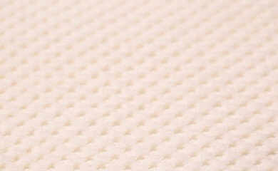 Knitted surface of woolen things as a background. Close-up of soft white texture of knitted patterns. Warm winter clothes. Background textile surface with copy space for text.