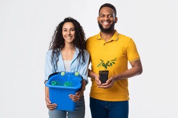 Couple Holding Plant And Plastic Bottles In Bucket, White Background