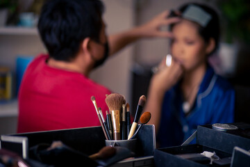 selective focus Make-up converter on makeup artist's table with lots of makeup artist tools. blur background makeup artist doing makeup beautiful girl There is space for text.