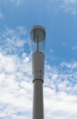 A typical small cell antenna for 5G wireless network installed on street lamp post isoleted on blue sky