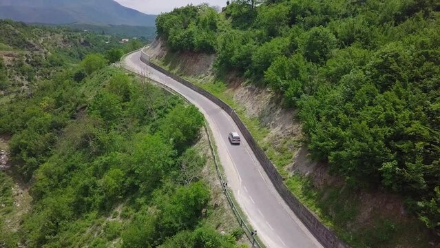 Van driving through the winding roads of Valbona Kukes in Albania, Eastern Europe. Aerial follow shot