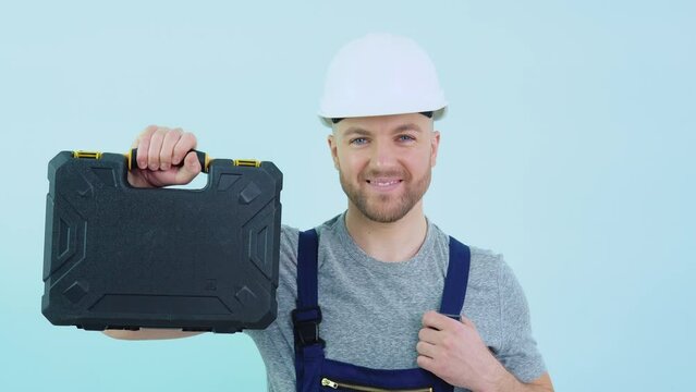 Serviceman in overalls showing his tools