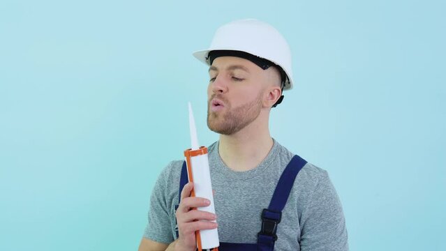 Handyman in overalls holding silicone adhesive