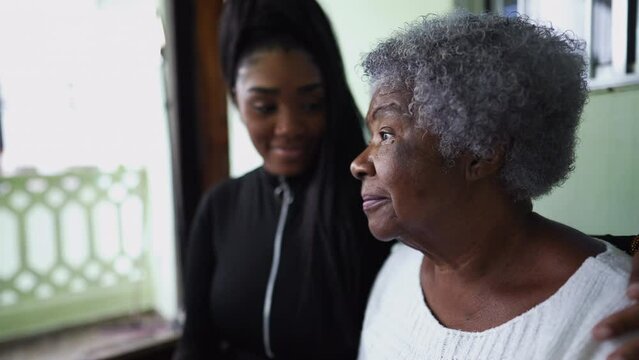 A teen granddaughter taking care of grandmother giving help and support