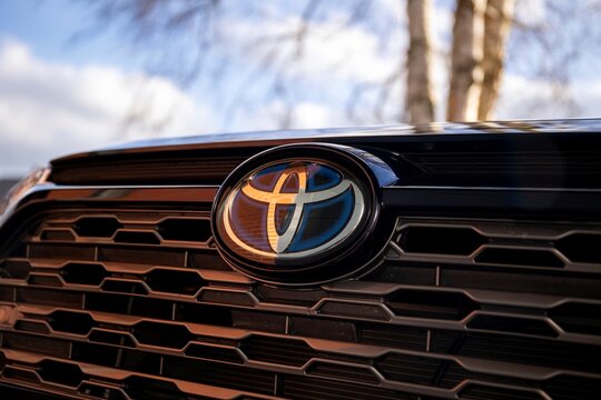 Brecht, Belgium - februari 5 2022: A close up portrait of the Toyota logo on a RAV4 SUV car. The front and mainly the grill of the vehicle is visible.