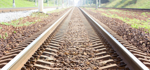 Railroad tracks in the countryside lead to the sunlight