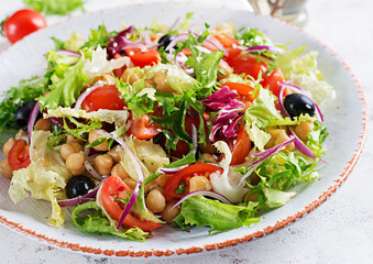 Healthy salad of chickpeas, tomatoes, olives and lettuce with red onion. Healthy food, diet. Closeup food.