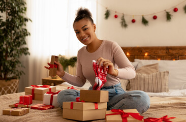 New year and Christmas celebration. Happy african american woman receiving xmas present and holding cute socks