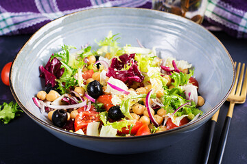 Healthy salad of chickpeas, tomatoes, olives and lettuce with red onion. Healthy food, diet. Closeup food.