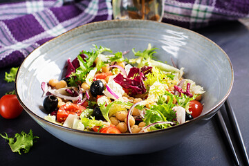 Healthy salad of chickpeas, tomatoes, olives and lettuce with red onion. Healthy food, diet. Closeup food.