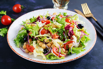 Healthy salad of chickpeas, tomatoes, olives and lettuce with red onion. Healthy food, diet. Closeup food.