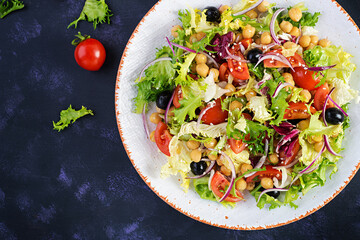 Healthy salad of chickpeas, tomatoes, olives and lettuce with red onion. Healthy food, diet. Closeup food. Top view, flat lay