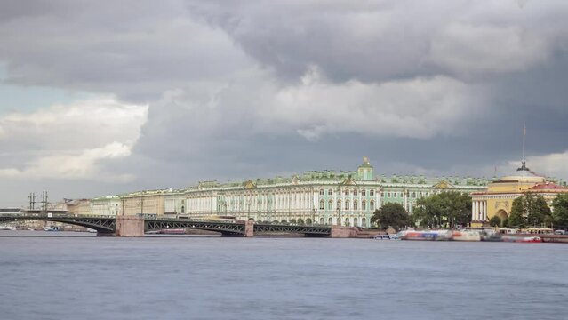 Dramatic cloudy sky over the Bridge and Winter Palace with boats on the Neva River. Saint Petersburg, Russia. Timlapse