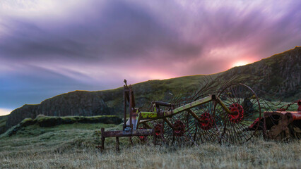 Fototapeta premium An old hay tedder at sunset