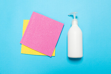 Detergent for various surfaces and rag sponge Light pastel blue background. Professional cleaning products, general cleaning. Household chemicals