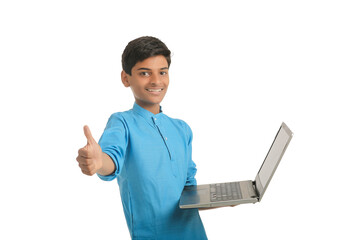 Technology concept : Cute indian little school boy using laptop