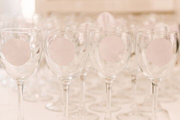Empty wine glasses with stickers with an empty logo space on a light background