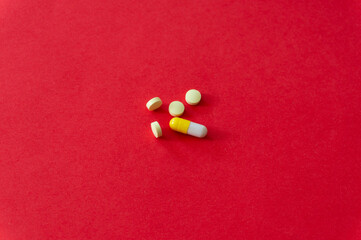 Medications and pills on a red background.