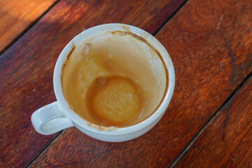 leftover coffee in a white ceramic cup on brown wooden table background, object, food, drink, copy space