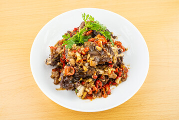 A plate of spicy beef ribs on a wooden table