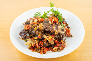 A plate of spicy beef ribs on a wooden table