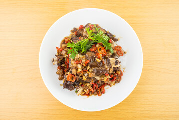 A plate of spicy beef ribs on a wooden table