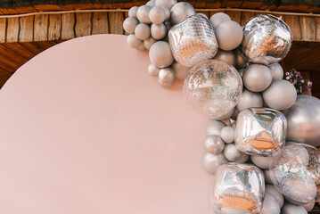 Round pink photo zone made of silver balloons with space to copy your text. Party decorated with...