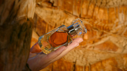 Perfume bottle against the backdrop of a palm tree