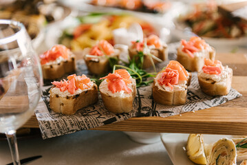 Beautifully decorated catering banquet table with different food snacks and appetizers with sandwich, fresh fruits on corporate party event or wedding celebration