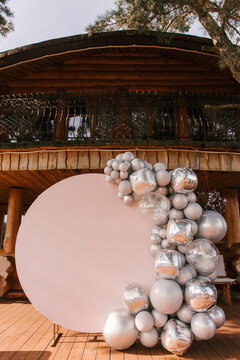 Round pink photo zone made of silver balloons with space to copy your text. Party decorated with balloons