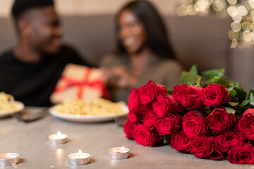 African American Couple Celebrating Valentine's Day Indoor, Focus On Bouquet