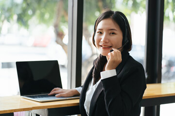 Young businesswoman with headset and laptop in a video call.