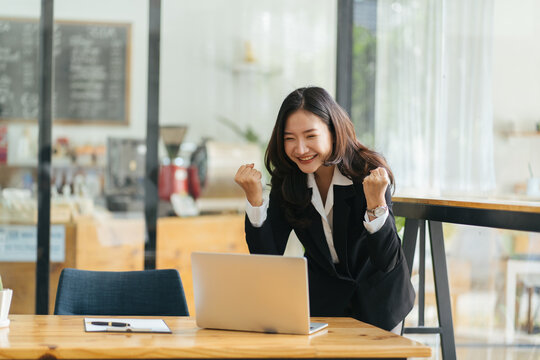 Excited Asian woman sit at desk feel euphoric win online lottery, happy black woman overjoyed get mail at laptop being promoted at work, biracial girl amazed read good news at computer