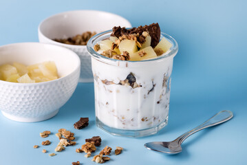 Healthy Breakfast: Yogurt Parfait With Granola Pineapple and Oatmeal Cookies Breakfast in Glass Blue Background