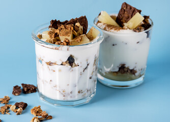 Healthy Breakfast: Yogurt Parfait With Granola Pineapple and Oatmeal Cookies Breakfast in Glass Blue Background