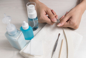 Obraz na płótnie Canvas A woman does a manicure at home. Manicure tools. Edged manicure. Dangerous manicure. Home care, Spa, beauty. Nail salon 