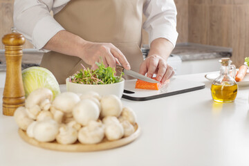 man cuts pepper on  table in  kitchen