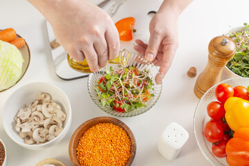 chef dressing fresh vegetable salad with olive oil