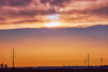 Naklejka na ściany i meble landscape with sunset over a high voltage line