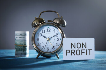 Non profit on business card with an alarm clock and money.