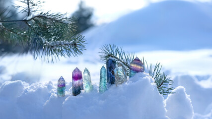 Crystals gemstones and pine branch on snow, natural winter background. minerals for esoteric...
