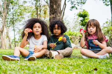Fototapeta premium happiness children caucasian blow soap bubble in park.