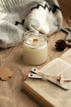 atmospheric and cozy picture. on a beige background a candle, a book, a bump