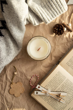 atmospheric and cozy picture. on a beige background a candle, a book, a bump